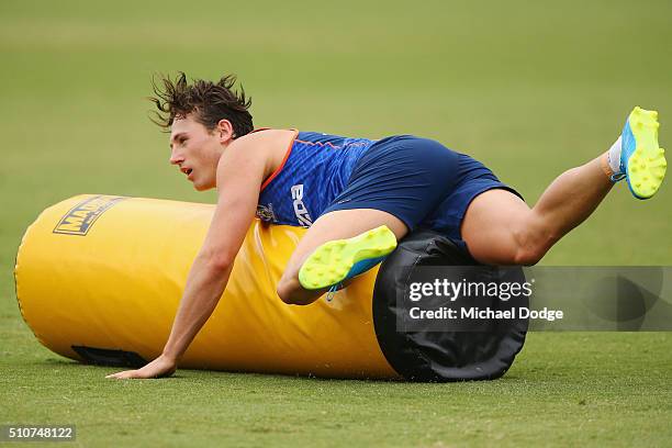 Ben Jacobs of the Kangaroos tackles a heavy bag during a North Melbourne Kangaroos AFL media session at Arden Street Ground on February 17, 2016 in...