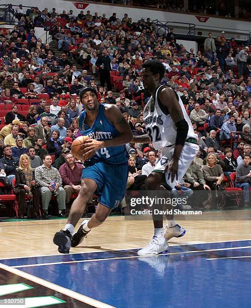 Lee Nailon of the Charlotte Hornets drives to the basket around Joe Smith of the Minnesota Timberwolves at Target Center in Minneapolis, Minnesota....