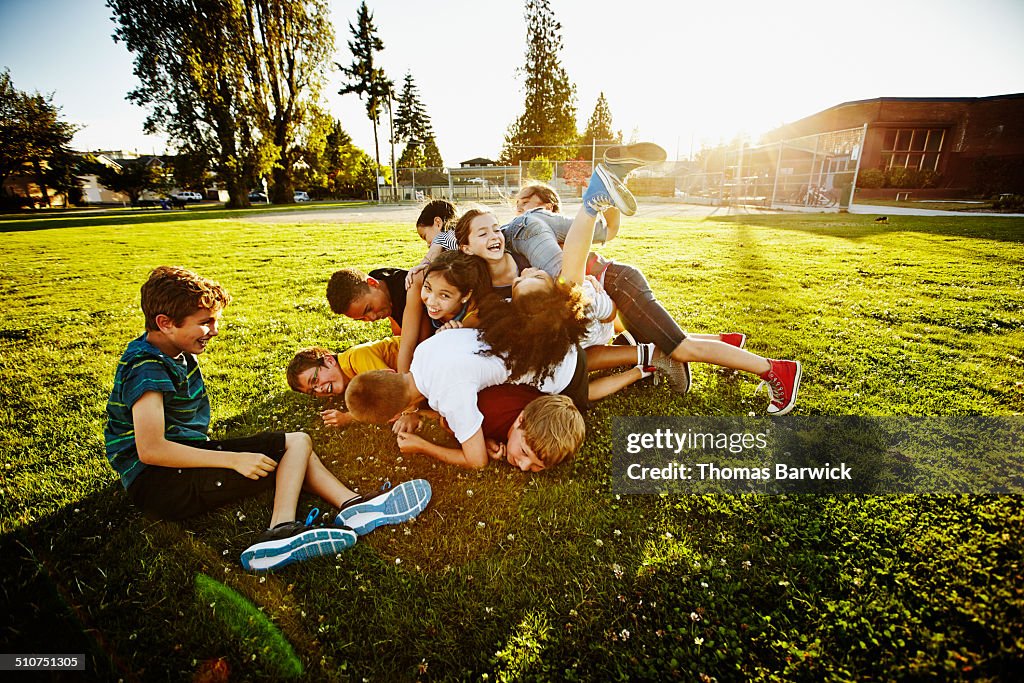 Group of kids tackling and piling on each other