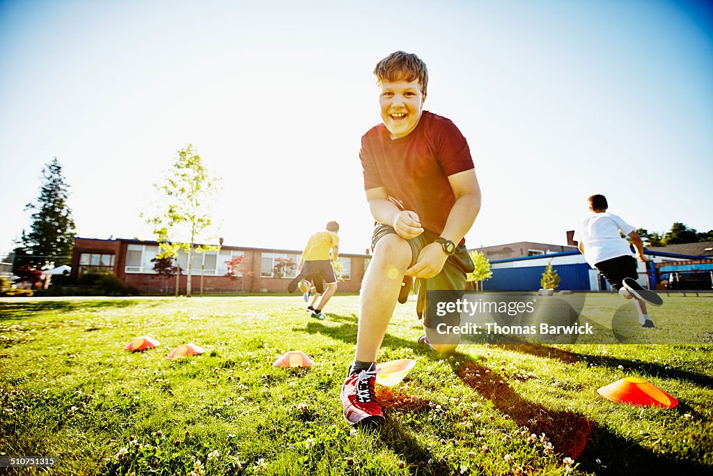 Boy running with classmates during athletics class