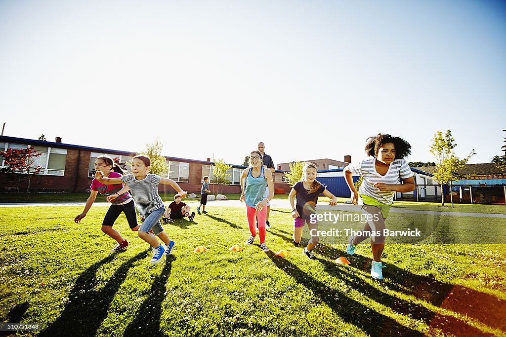 Group of girls running race during athletics class