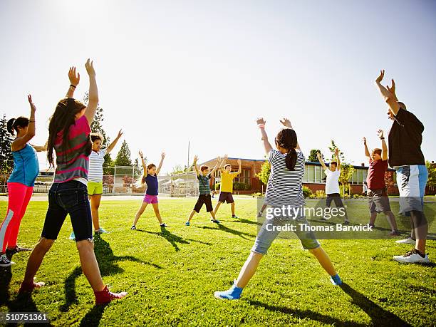 group of kids in athletics class with coach - sport community center stock pictures, royalty-free photos & images