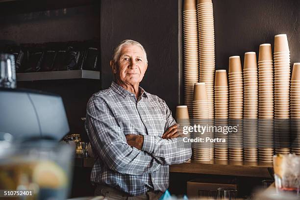 confident senior owner standing at cafe - plaid shirt 個照片及圖片檔