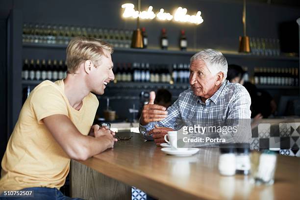 father and son having coffee at cafe - 70 79 years stock pictures, royalty-free photos & images