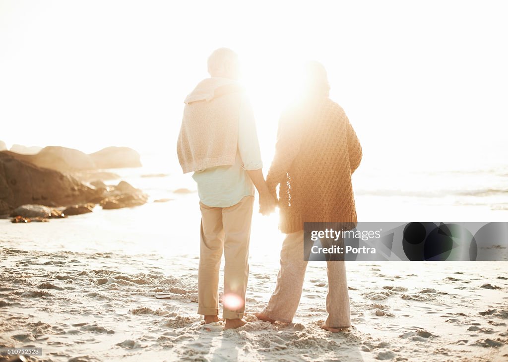 Senior couple holding hands on beach