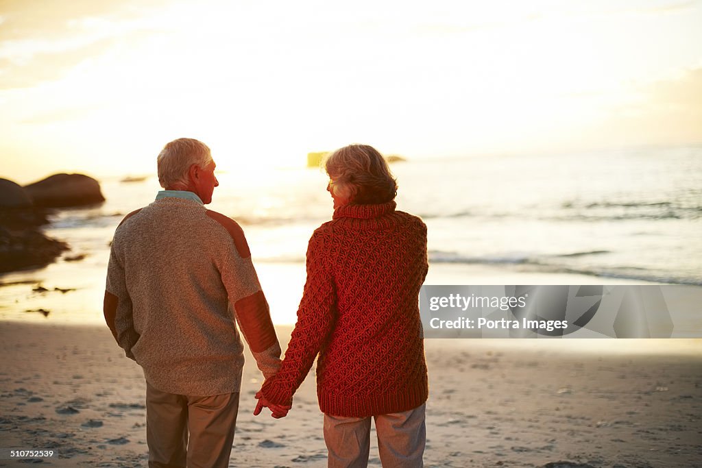Senior couple holding hands on beach