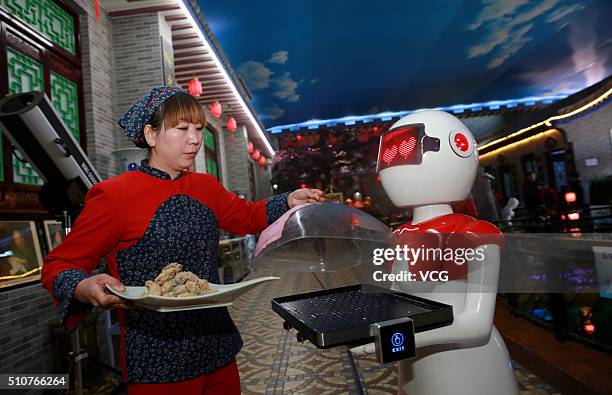 An intelligent robot delivers meals for customers at a farmhouse restaurant in Shanzhou District on February 16, 2016 in Sanmenxa, Henan Province of...