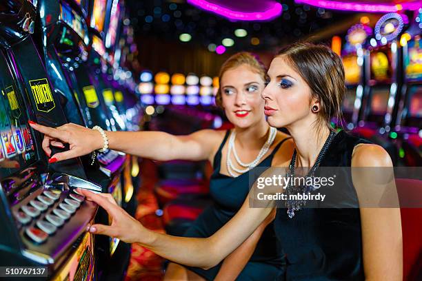 girls having fun with slot machine in casino - teen pokies stock pictures, royalty-free photos & images