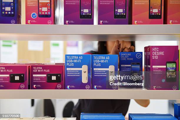 An employee places a boxed Samsung Electronics Co. Galaxy Core Prime smartphone on a shelf inside a Telstra Corp. Discovery store in Melbourne,...