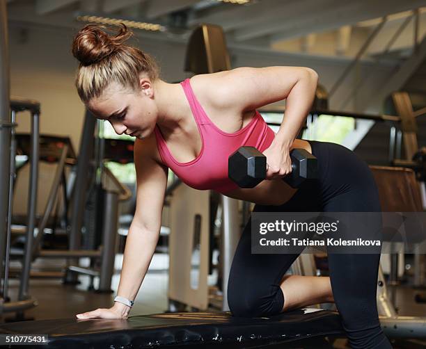 young woman exercising with dumbbells - girl in gym stock-fotos und bilder