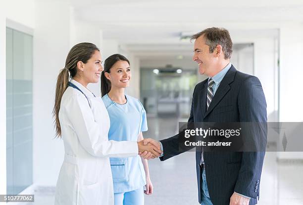 doctor greeting health insurance agent with a handshake - director 個照片及圖片檔