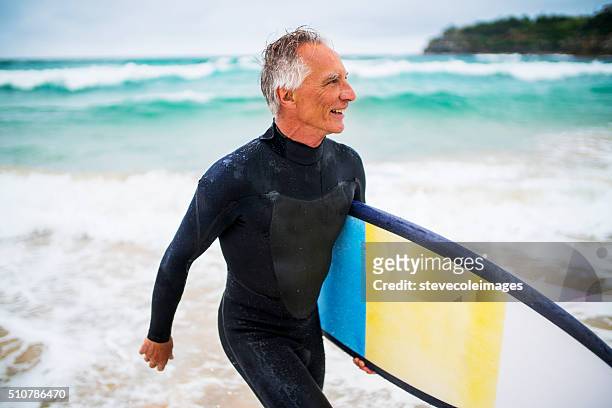 alter mann und surf brett - surfer australia stock-fotos und bilder