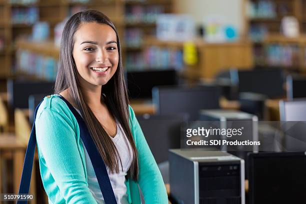 hispanic teenage girl in high school computer lab - high tech beauty stockfoto's en -beelden