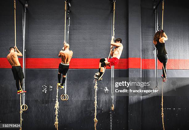 group of athlete climbing the rope on a gym - man muscular build stock pictures, royalty-free photos & images