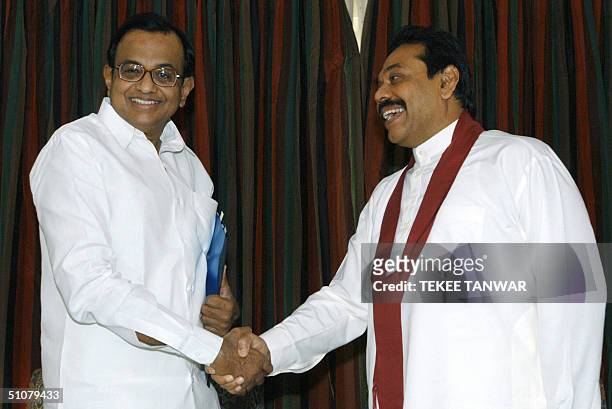 Sri Lankan Prime Minister Mahinda Rajapakse shakes hands with India's Finance Minister P. Chidambaram prior to a meeting in New Delhi, 18 July 2004....
