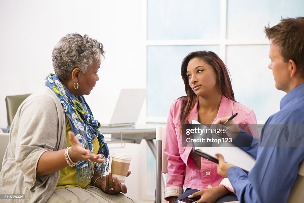 Therapist takes notes in counseling session. Mother, daughter clients.