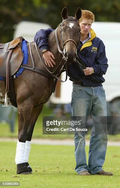 Prince Harry with his arm around the neck of a pony at Cirencester Polo Club, Gloucestershire on July 18, 2004.