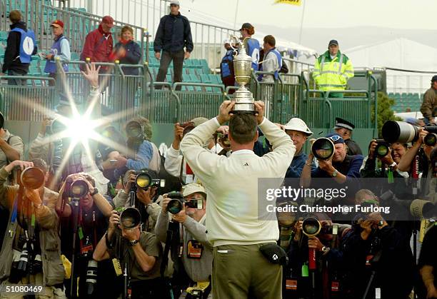 Todd Hamilton of USA poses with the claret jug on bis head in front of photographers after securing victory in the 133rd Open Championship, after a...