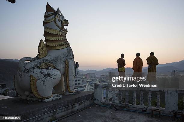 Three young monks stand on a railing overlooking the city on February 16, 2016 in Mong La, Myanmar. Mong La, the capital of Myanmar's Special Region...