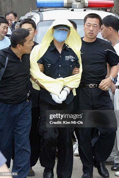 Suspected serial killer, Yoo Young-Chul , is escorted by South Korean police during an inspection of suspected murder sites on July 19, 2004 in...