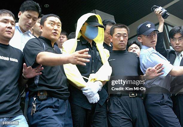 Suspected serial killer, Yoo Young-Chul , is escorted by South Korean police during an inspection of suspected murder sites on July 19, 2004 in...