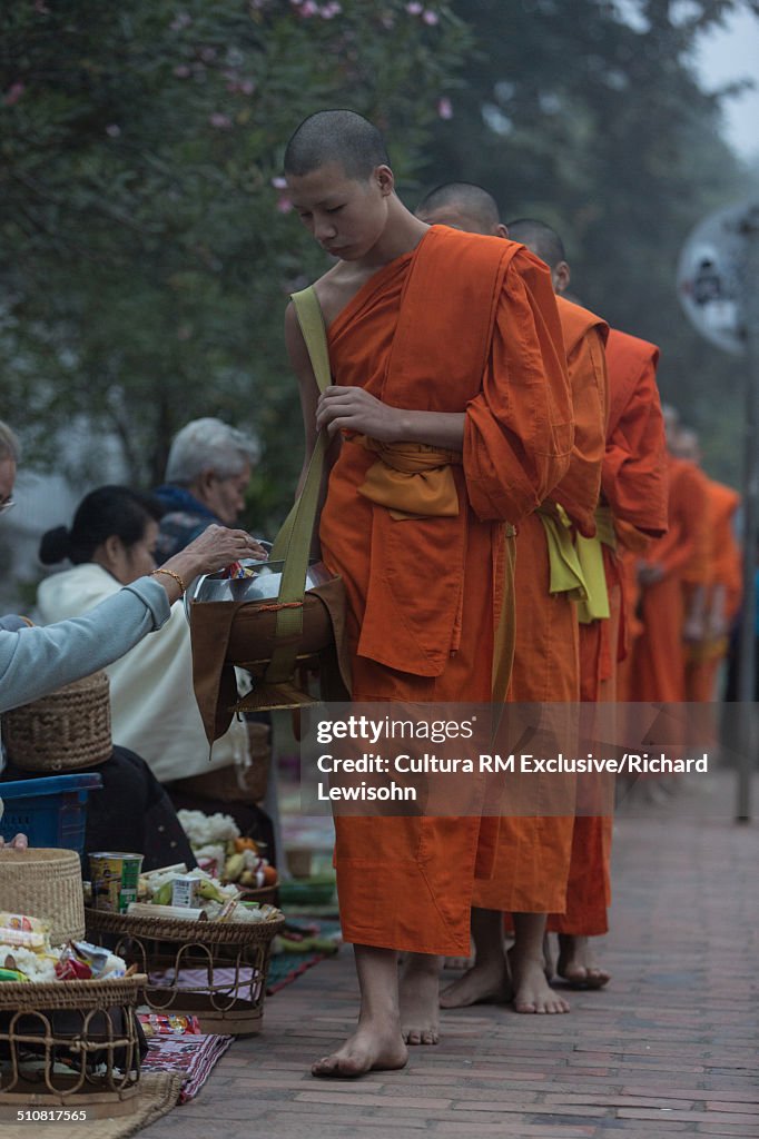 Alms giving ceremony, Sisavangvong road, Luang Prabang, Laos, Southeast Asia