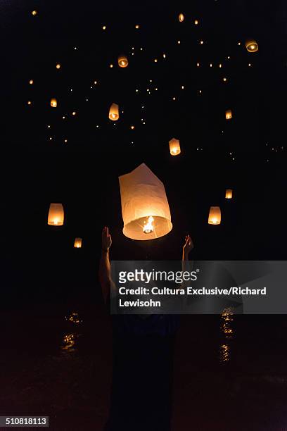 boy releasing chinese lanterns on new year's eve, krabi, thailand, southeast asia - paper lantern stockfoto's en -beelden