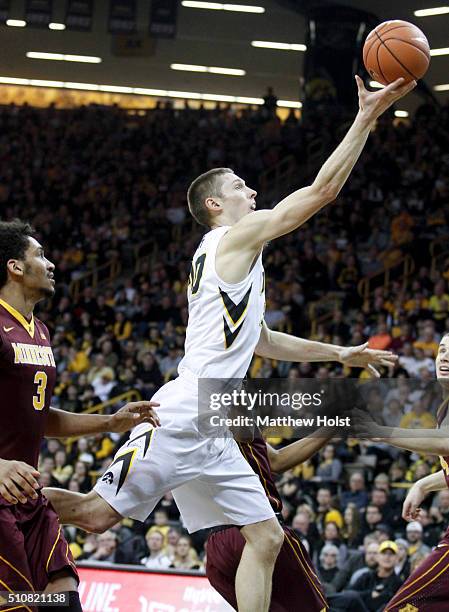 Forward Jarrod Uthoff of the Iowa Hawkeyes drives to the basket against forward Jordan Murphy and guard Dupree McBrayer of the Minnesota Golden...