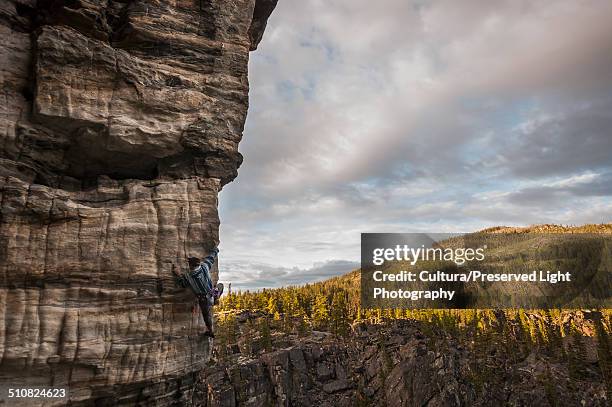 male rock climber, climbing a rock wall at boulder fields, south okanagan valley, kelowna, british columbia, canada - kelowna stock pictures, royalty-free photos & images