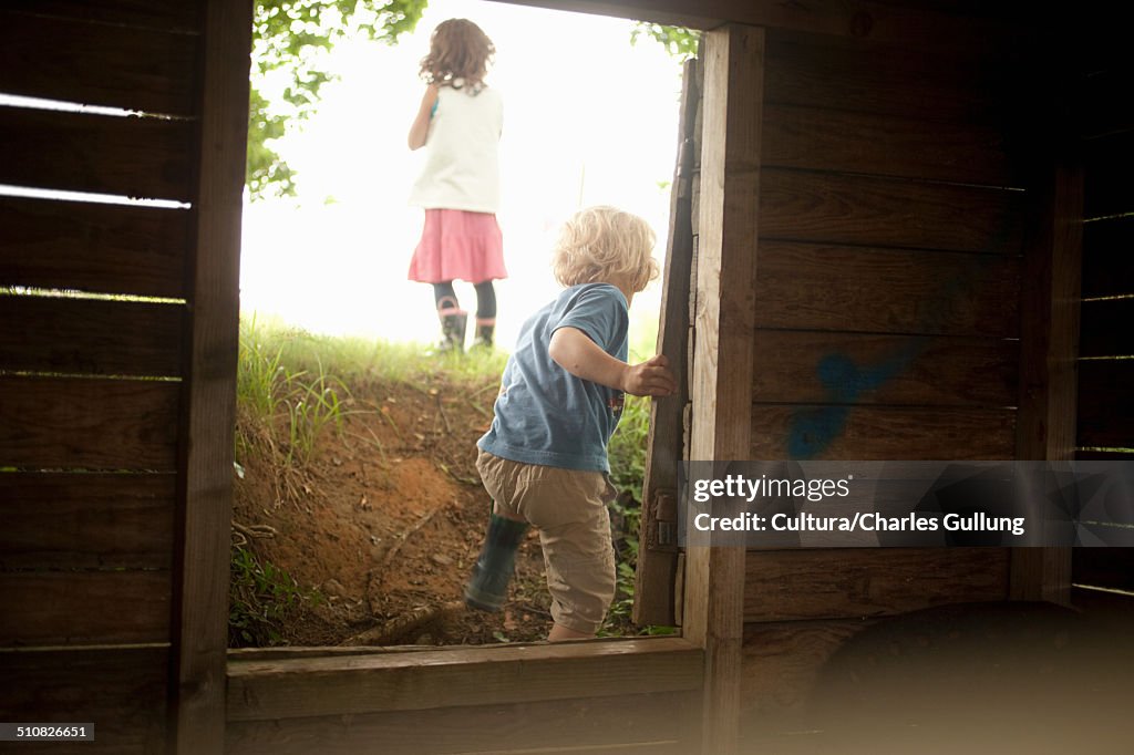 Boy and girl leaving through wooden window frame