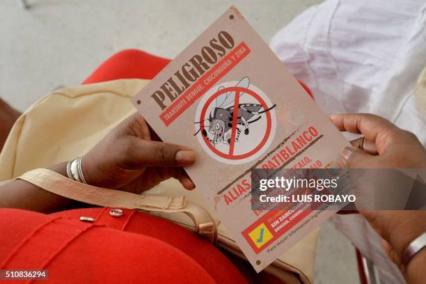 Woman holds a leaflet with information on the Aedes aegypti mosquito on February 17 in Cali, Colombia. Cali's Health Secretariat massively delivered...