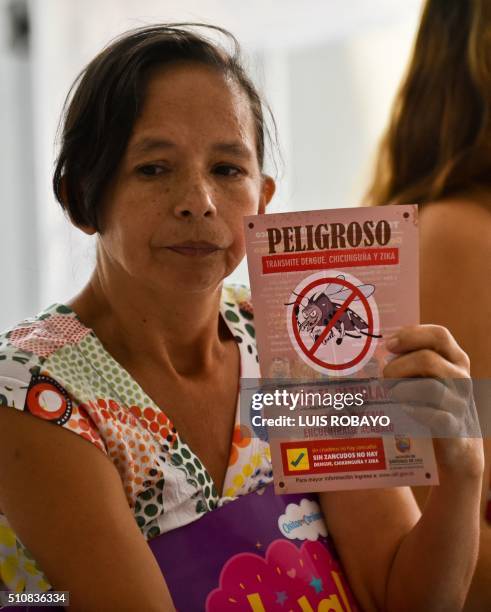 Woman shows a leaflet with information on the Aedes aegypti mosquito on February 17 in Cali, Colombia. Cali's Health Secretariat massively delivered...