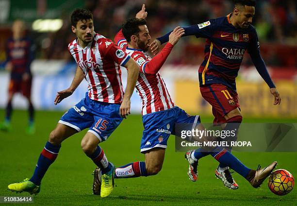 Barcelona's Brazilian forward Neymar controls the ball next to Sporting Gijon's defenders Alex Menendez and Roberto Canella during the Spanish league...