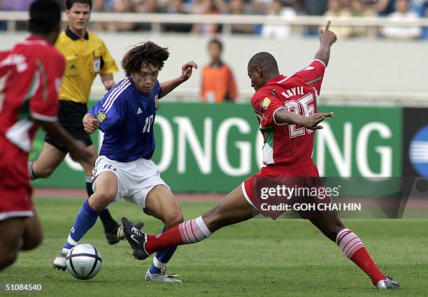 Japan's Shunsuke Nakamura avoids a tackle by Oman's Khalifa Al-Naufali during the Asian Cup Group D match 20 July 2004 in the southwestern Chinese...