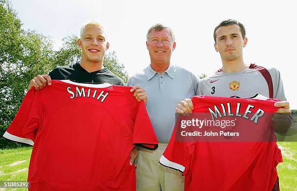 Alan Smith and Liam Miller of Manchester United pose with Sir Alex Ferguson and a United shirt before a press conference to unveil United's new...