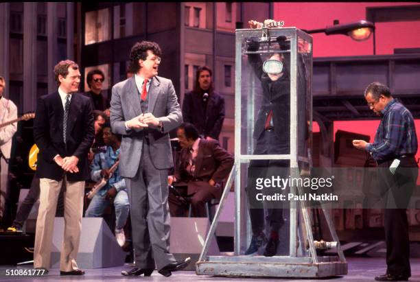American magicians Penn and Teller perform a card trick with a water tank on and episode of the Late Night with David Letterman television show,...