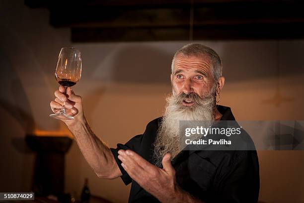 senior man with beard tasting red wine in cellar, europe - sommelier stock pictures, royalty-free photos & images