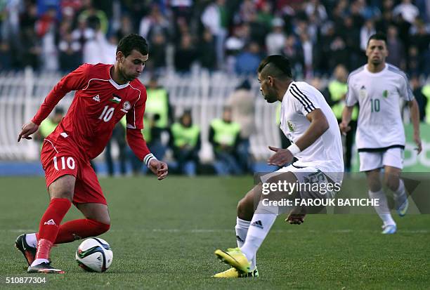 Palestinian player Sameh Marraba vies for the ball with Algerian player Houari Ferhani during a friendly football match between the Palestinian and...