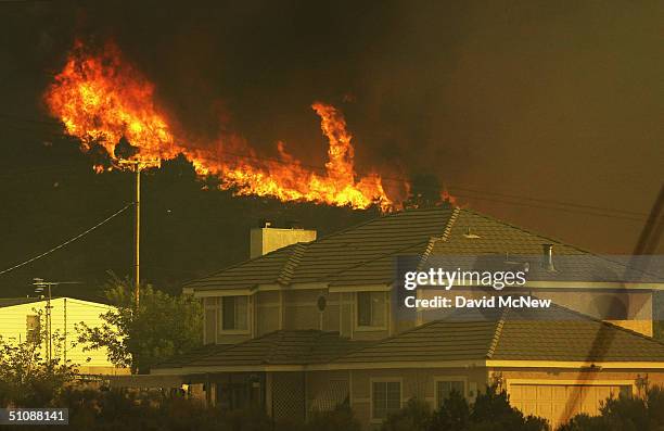 Flames advance toward houses at the Crown Fire on July 20, 2004 near Acton, California. The fire is threatening hundreds of homes but has so far...