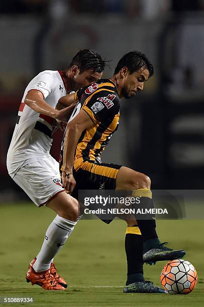 Matias Alonso of Bolivia's The Strongest, vies for the ball with Mena of Brazils Sao Paulo, during their 2016 Copa Libertadores football match held...