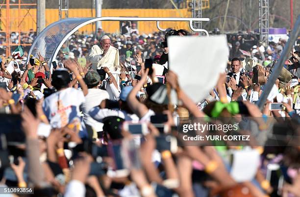 Pope Francis waves as he arrives on the popemobile to celebrate mass at the Ciudad Juarez fairgrounds in Chihuahua state, Mexico on February 17,...