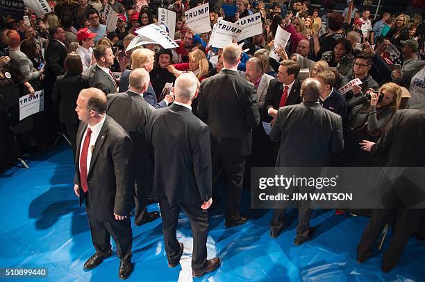 Secret Service officers surround Republican presidential candidate Donald Trump as he signs autographs for supporters during a campaign rally in...