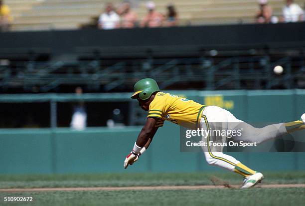 Outfielder Rickey Henderson of the Oakland Athletics dives into second base against the Baltimore Orioles during an Major League Baseball game circa...