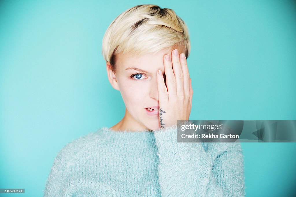 Young beautiful woman with one hand over one eye