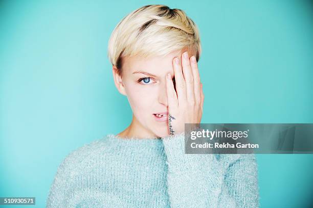 young beautiful woman with one hand over one eye - blue eyes stock pictures, royalty-free photos & images
