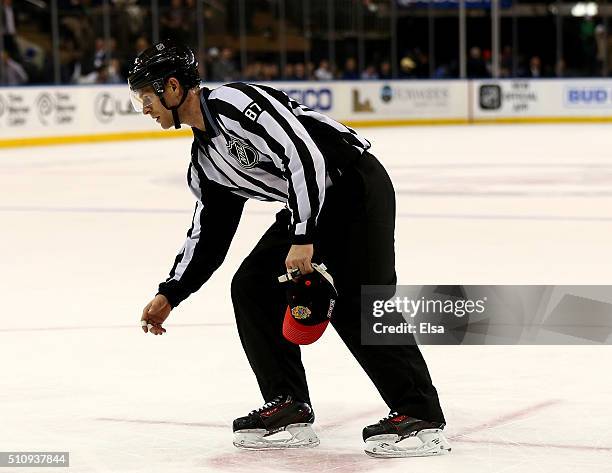 Devin Berg picks up hats thrown on the ice after Artemi Panarin of the Chicago Blackhawks scored a hat trick in the third period against the New York...