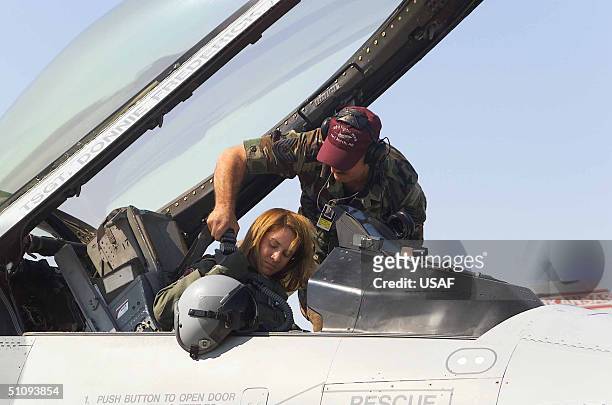 Second Lt. Kristin L. Bass, An F-16 Fighting Falcon Pilot From The Arkansas Air National Guard's 188Th Fighter Wing Gets Strapped In By Crew Chief...