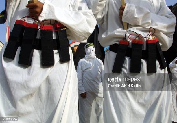Masked Islamic Jihad Militants Wear Explosive Belts During A Rally Commemorating Mohammed Irhaem And Saleh Hassouna April 23, 2002 In Gaza City, Gaza...