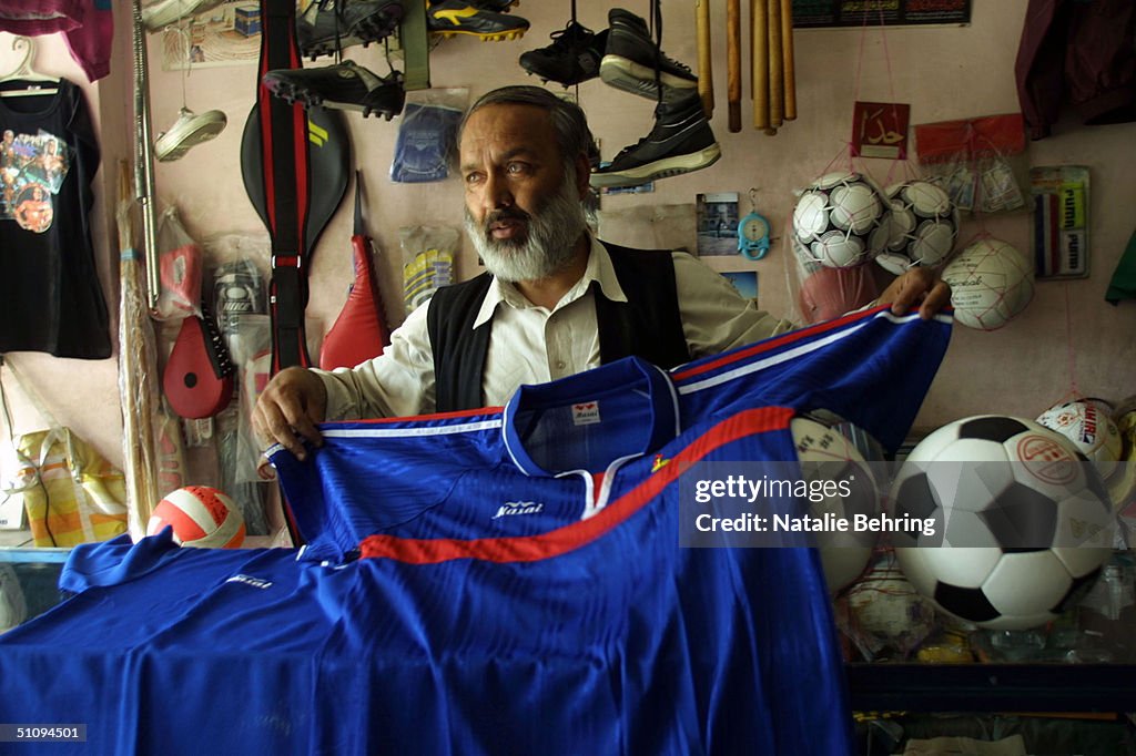 Afghan Shop Owner Shows Potential Customers A French Football Jersey