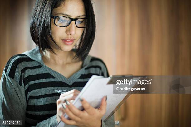 asian young woman writing on clipboard. - human body part stock pictures, royalty-free photos & images